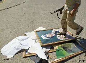 A Libyan rebel fighter stamps on a portrait of Moammar Gadhafi , in Tripoli, Libya, Thursday, Aug. 25, 2011. Libya's rebel leadership has offered a 2 million dollar bounty on Gadhafi's head, but the autocrat has refused to surrender as his 42-year regime crumbles, fleeing to an unknown destination. Speaking to a local television channel Wednesday, apparently by phone, Gadhafi vowed from hiding to fight on until victory or martyrdom. (Foto:Francois Mori/AP/dapd)