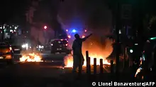28.6.2023 *** TOPSHOT - A man walks past a bonfire in a residential area during clashes in Toulouse, southwestern France on June 28, 2023, a day after the killing of a 17 year old boy in Nanterre by a police officer's gunshot following a refusal to comply. France braced for more angry protests on June 28, 2023 after the killing of a teenager by police during a traffic stop that President Emmanuel Macron called unforgivable. (Photo by Lionel BONAVENTURE / AFP)