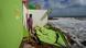 Man standing amid debris looking at the sea Man standing amid debris looking at the sea