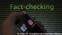May 9, 2019 - Asuncion, Paraguay - Hand holds a smartphone displaying Facebook and Instagram logo icon against the text fact-checking on background. (Credit Image: Â© Andre M. Chang/ZUMA Wire