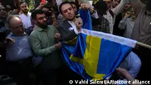 30/06/2023 00:00:00
Iranian demonstrators burn a Swedish flag during a protest of the burning of a Quran in Sweden, in front of the Swedish Embassy in Tehran, Iran, Friday, June 30, 2023. On Wednesday, a man who identified himself in Swedish media as a refugee from Iraq burned a Quran outside a mosque in central Stockholm. (AP Photo/Vahid Salemi)