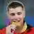 Weltmeister David Storl beisst in seine Goldmedaille bei der Leichtathletik WM in Daegu. (Daniel Maurer/dapd)