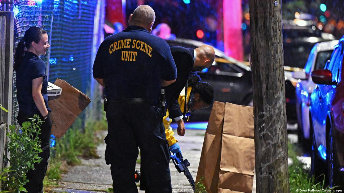 La policía coloca un rifle en una bolsa en la escena del tiroteo en Kingsessing. La policía coloca un rifle en una bolsa en la escena del tiroteo en Kingsessing.