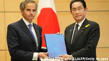 Rafael Grossi (L), Director General of the International Atomic Energy Agency (IAEA), hands over a report by IAEA to Japan's Prime Minister Fumio Kishida during their meeting at the prime minister's residence in Tokyo on July 4, 2023. (Photo by ZHANG Xiaoyu / POOL / AFP) (Photo by ZHANG XIAOYU/POOL/AFP via Getty Images)