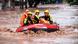 Rescue workers evacuate stranded residents on a flooded street Rescue workers evacuate stranded residents on a flooded street