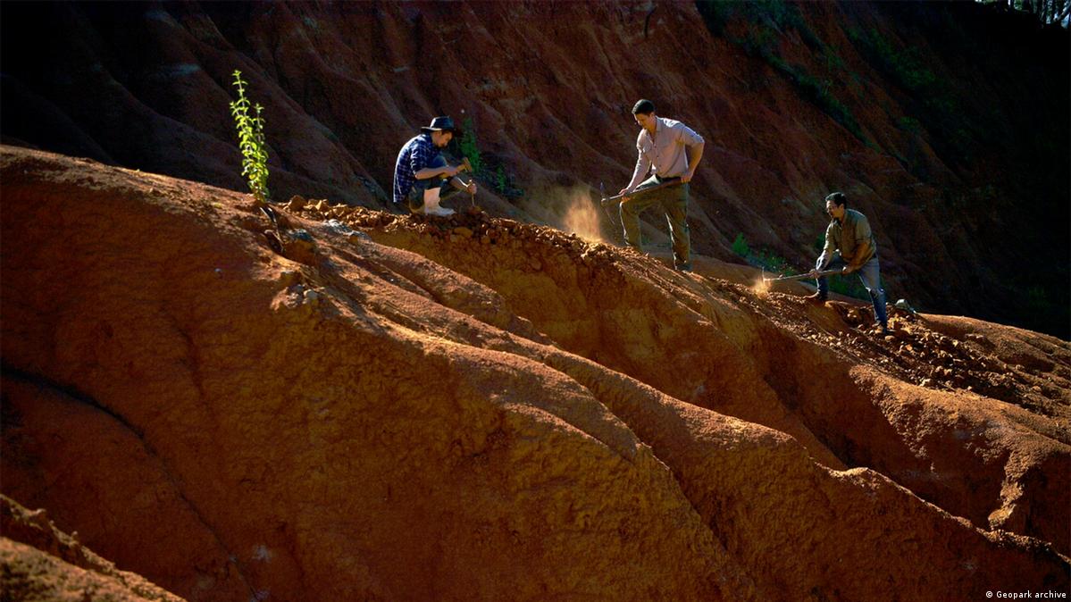 Três homens escavam a terra em um geossítio.Paleontólogos realizando trabalho de campo no geossítio Janner no afloramento Várzea do Agudo, no Geoparque Quarta Colônia. 
