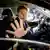 Mark Rutte se despide con la mano desde el interior de un automóvil, sentado al volante.