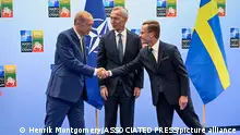 10.7.2023, Vilnius, Litauen, Turkish President Recep Tayyip Erdogan, left, and Swedish Prime Minister Ulf Kristersson shake hands next to NATO Secretary-General Jens Stoltenberg prior to their meeting, on the eve of a NATO summit, in Vilnius, Monday July 10, 2023. Erdogan on Monday introduced a new condition for approving Sweden’s membership in NATO, calling on European countries to “open the way” for Turkey to join the European Union. (Henrik Montgomery/TT News Agency via AP)