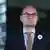 Visoki predstavnik u BiH Christian Schmidt zamišljeno gleda u daljinu. Na lijevoj strani sakoa nosi "Cvijet Srebrenice"