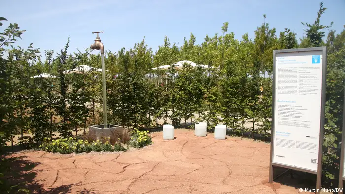Eine Wasserhahn-Skulptur auf der Bundesgartenschau 2023, davor trockene Erde