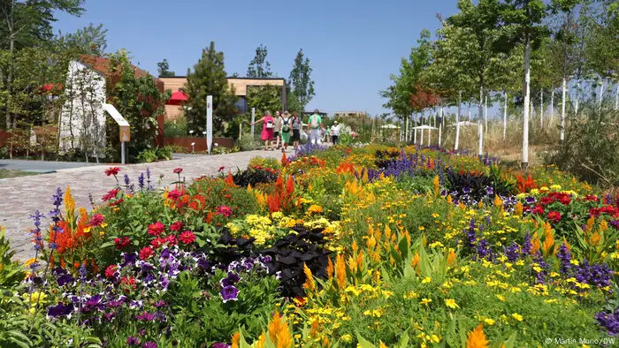 Auf der Bundesgartenschau 2023 laufen Besucher an einem Blumenbeet entlang 