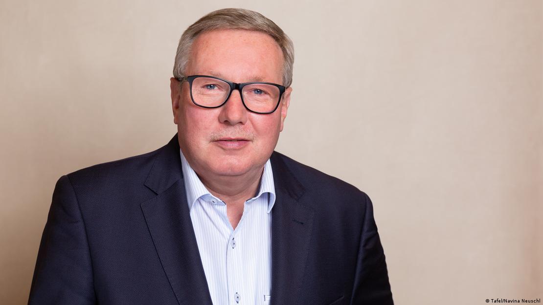 Ein Mann in seinem Hemd, blaue Jacke und schwarze Brille sehen die Kamera an: Andreas Stepuhn