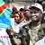 Cherubin Okende photographie avec une casquette et un drapeau congolais, de son vivant, en mars 2023