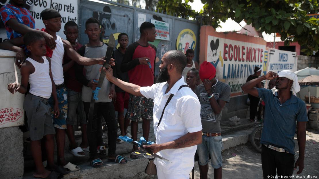 Nertil Marcelin, leader of the "Bwa Kale" community group, distributes machetes to residents in an initiative to fight gangs seeking to take control of their neighborhood in the Delmas district of Port-au-Prince, Haiti, Sunday, May 28, 2023. 
