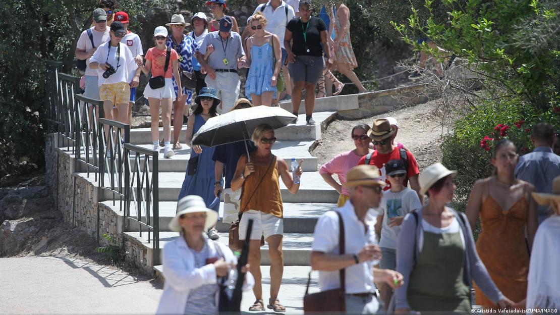Pessoas com roupas de verão e óculos de sol descem uma escada