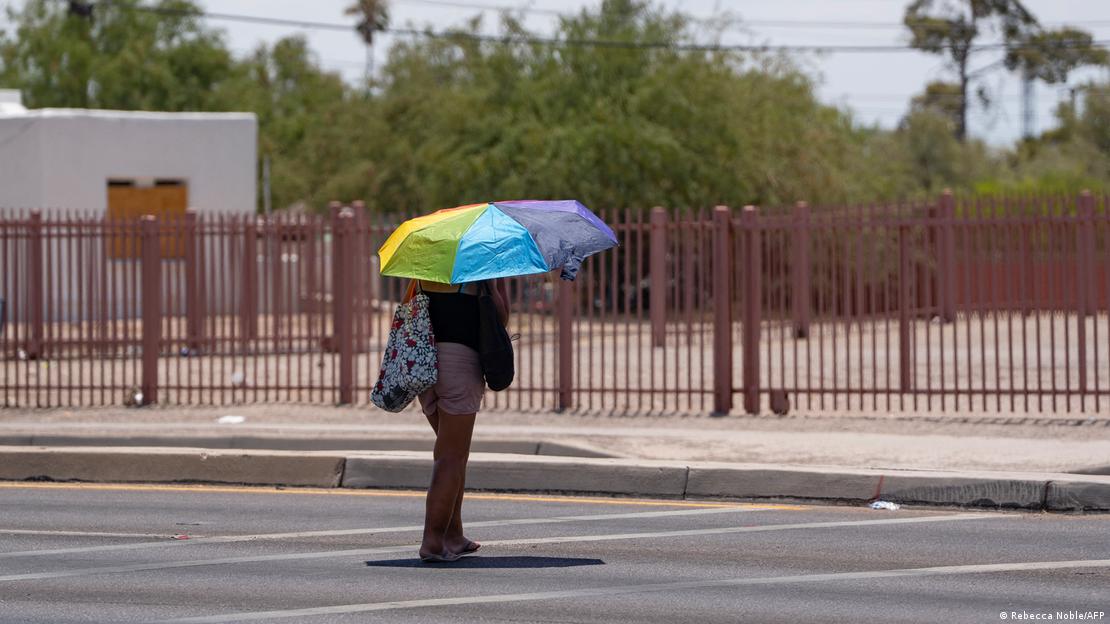 Mulher anda na rua sob um guarda-sol em Tuscon, no Arizona