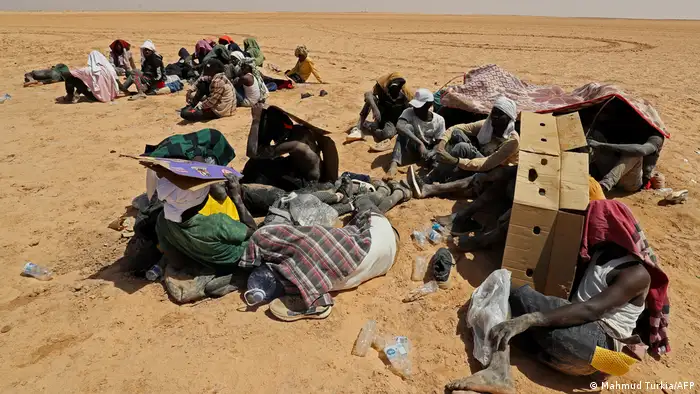 مهاجرون من دول أفريقيا جنوب الصحراء في الصحراء قرب الحدود التونسية الليبية. 