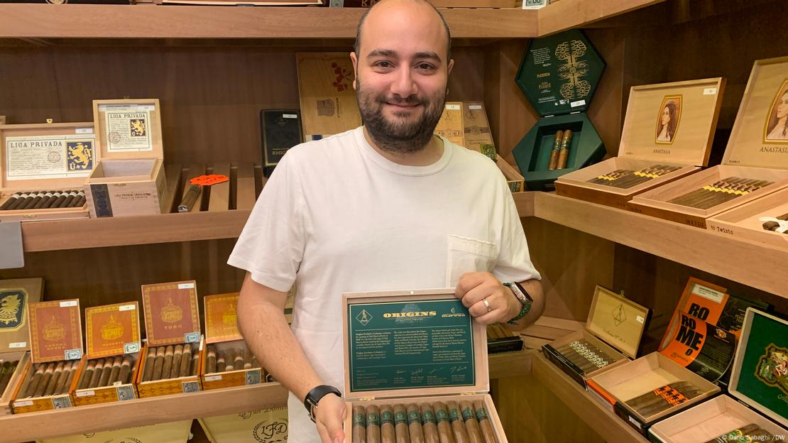 Woody Ghsoubi, the co-owner of Club Mareva Beirut, stands inside the humidor room, displaying a box of a limited-edition cigar