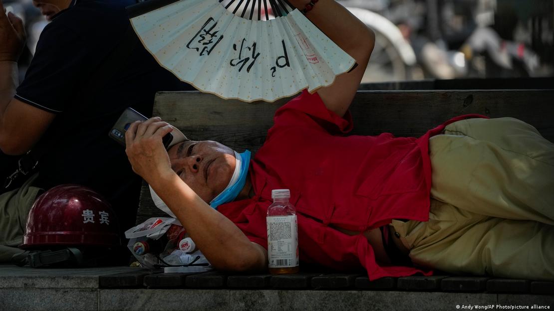 Γυναίκα στο Πεκίνο προσπαθεί να προστατευθεί από τη ζέστη 