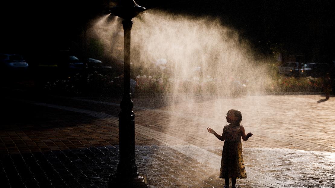 Polonya'da, püskürtülen su ile bunaltıcı sıcakta ferahlamaya çalışan bir çocuk - (20.06.2023 / Krakow)