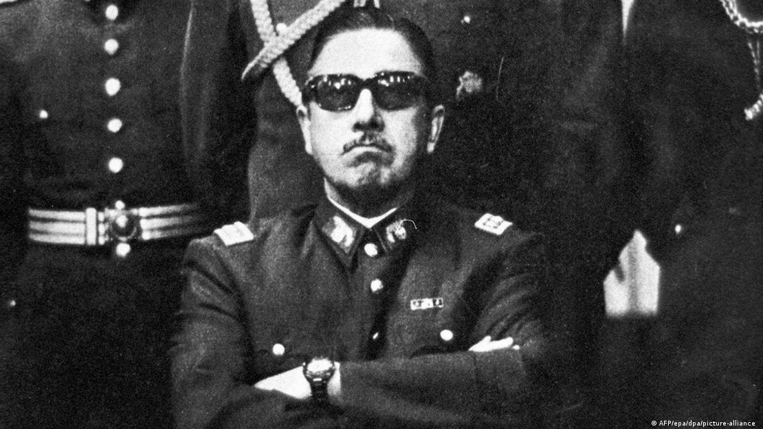Şilili darbeci general Augusto Pinochet, ellerini önünde kavuşturmuş ciddi bir yüz ifadesi ile bakıyor