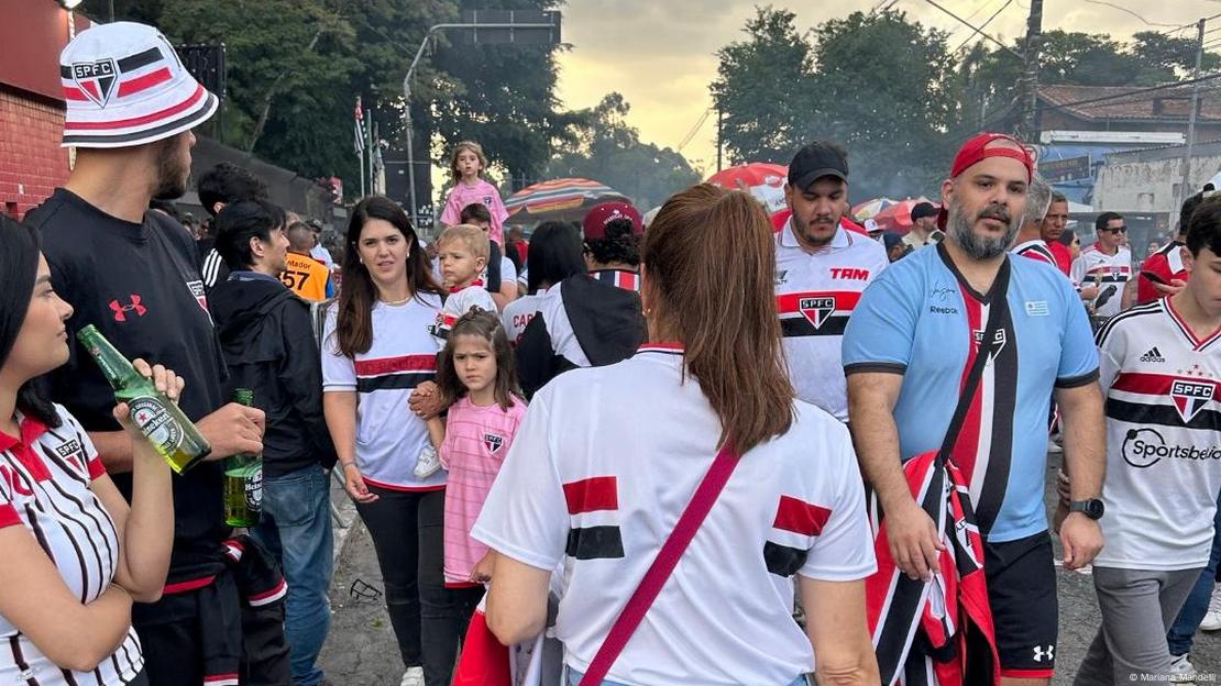 Mulheres e homens com camisa de futebol