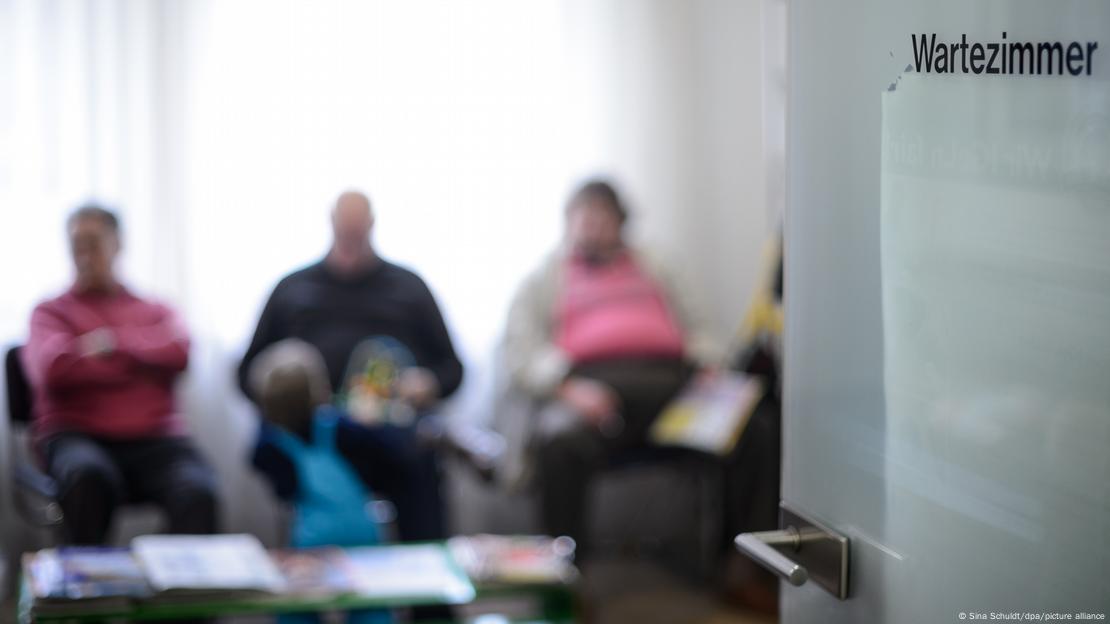 Pacientes sentados en la sala de espera de un consultorios. 