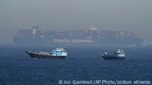 Two traditional dhows sail by a large container ship in the Strait of Hormuz Friday, May 19, 2023. The Mideast-based chiefs of the U.S., British and French navies transited the Strait of Hormuz on Friday aboard an American warship, a sign of their unified approach to keep the crucial waterway open after Iran seized two oil tankers. (AP Photo/Jon Gambrell)