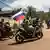Apoiador de Ibrahim Traoré, líder interino de Burquina Fasso desde o golpe de Estado de 30 de setembro de 2022, agita uma bandeira russa em uma motocicleta em 2 de outubro de 2022.