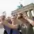 A woman and a man stand in front of the Brandenburg Gate in Berlin and take a selfie, Germany.