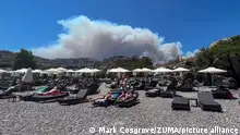 July 22, 2023, Lindos, Lindos, Greece: Smoke from Wildfire's looms over the holiday island of Rhodes as Wildfire's reignite due to strong winds views from Viglika Beach, Near Lindos, Greece, 22nd July 2023. (Credit Image: Â© Mark Cosgrove/News Images via ZUMA Press Wire