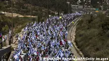 Demonstrators wave Israeli national flags as they march on the highway near the town of Mevasseret Zion on July 22, 2023, during a multi-day march from Tel Aviv to Jerusalem to protest the government's judicial overhaul bill ahead of a vote in the parliament. Israel has been rocked by a months-long wave of protests after the government unveiled in January plans to overhaul the judicial system that opponents say threaten the country's democracy. (Photo by MENAHEM KAHANA / AFP) (Photo by MENAHEM KAHANA/AFP via Getty Images)
