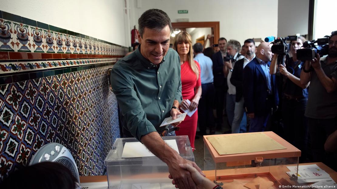 Spain's Prime Minister Pedro Sanchez greets an election official before voting at a polling station in Madrid