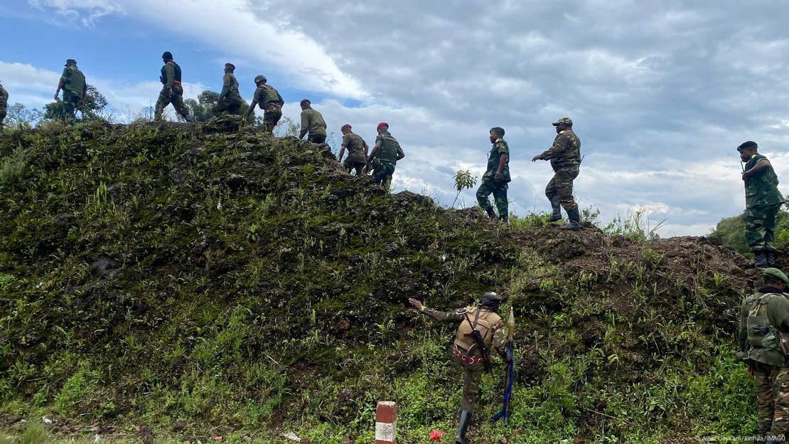 Homens em roupas militares andando em cima de uma colina na República Democrática do Congo