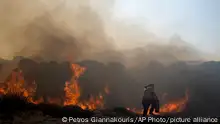 24.07.2023+++ A man tries to extinguish a fire, near the seaside resort of Lindos, on the Aegean Sea island of Rhodes, southeastern Greece, on Monday, July 24, 2023. A weeklong wildfire on the Greek resort island of Rhodes tore past defenses Monday, forcing more evacuations, as three major fires raged elsewhere in the country fueled by strong winds and successive heat waves that left scrubland and forests tinder-dry. (AP Photo/Petros Giannakouris)