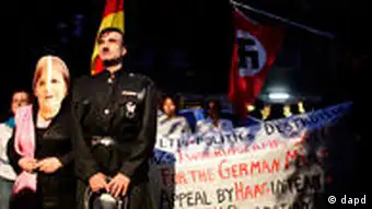 Actors impersonating German Chancellor Angela Merkel and former German dictator Adolf Hitler stand in front of demonstrators holding up banners and a Nazi flag during a during a protest outside the German embassy in the Greek capital Athens, on Thursday Oct. 6, 2011. The small group of protesters said Germany must pay Greece reparations for its occupation of the country during WWII before Greece pays off its debts. (Foto:Kostas Tsironis/AP/dapd)