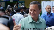 Hun Manet, center, of the Cambodian People's Party (CPP), son of Cambodia Prime Minister Hun Sen, also army chief, shows off his inked finger outside a polling station after voting in Phnom Penh, Cambodia, Sunday, July 23, 2023. Hun Sen has suggested he will hand off the premiership during the upcoming five-year term to his oldest son, Hun Manet, perhaps as early as the first month after the elections. (AP Photo/Heng Sinith)