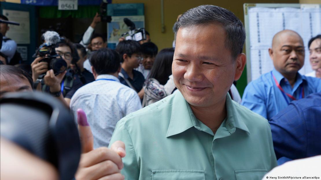 New Prime Minister Hun Manet shows ink on his finger after voting in July 2023