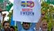 A man holds a sign reading "Boycott Sweden, All Muslims Come Together" as another man next to him holds up a Quran A man holds a sign reading "Boycott Sweden, All Muslims Come Together" as another man next to him holds up a Quran