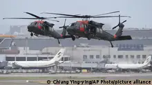 Two Sikorsky UH-60 Black Hawk helicopters approach during the annual Han Kuang military exercises that simulate an attack on an airfield at Taoyuan International Airport in Taoyuan, northern Taiwan, Wednesday, July 26, 2023. Taiwan military mobilized for routine defense exercises from July 24-28. (AP Photo/Chiang Ying-ying)