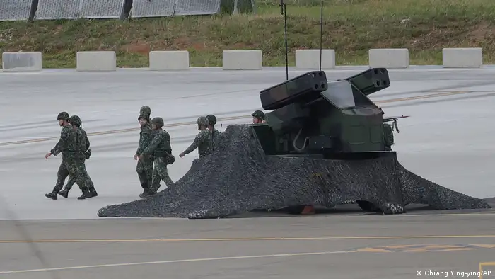 7月26日台湾“汉光”年度演习期间，一对台军士兵正在桃园国际机场的一辆军车旁走过，车上安装有多枚美制“毒刺”便携防空导弹发射装置