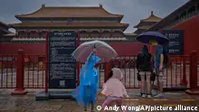 Children wearing raincoats play at the closed Forbidden City as a rainstorm soak Beijing, Sunday, July 30, 2023. Forbidden City and other tourist destinations in the capital city were ordered to close after authorities issued a red alert for rainstorms, as heavy rains brought by Typhoon Doksuri are expected to pound the Chinese capital and vast areas in the north. (AP Photo/Andy Wong)