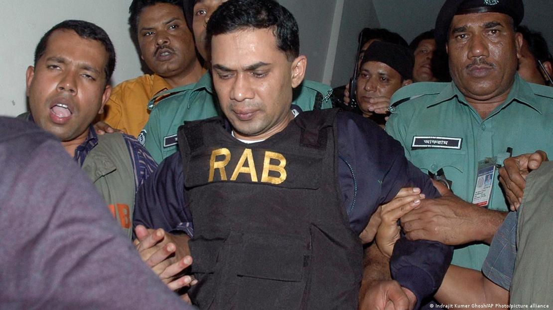 Tarique Rahman, wearing a bulletproof vest, being taken to a courtroom in 2007
