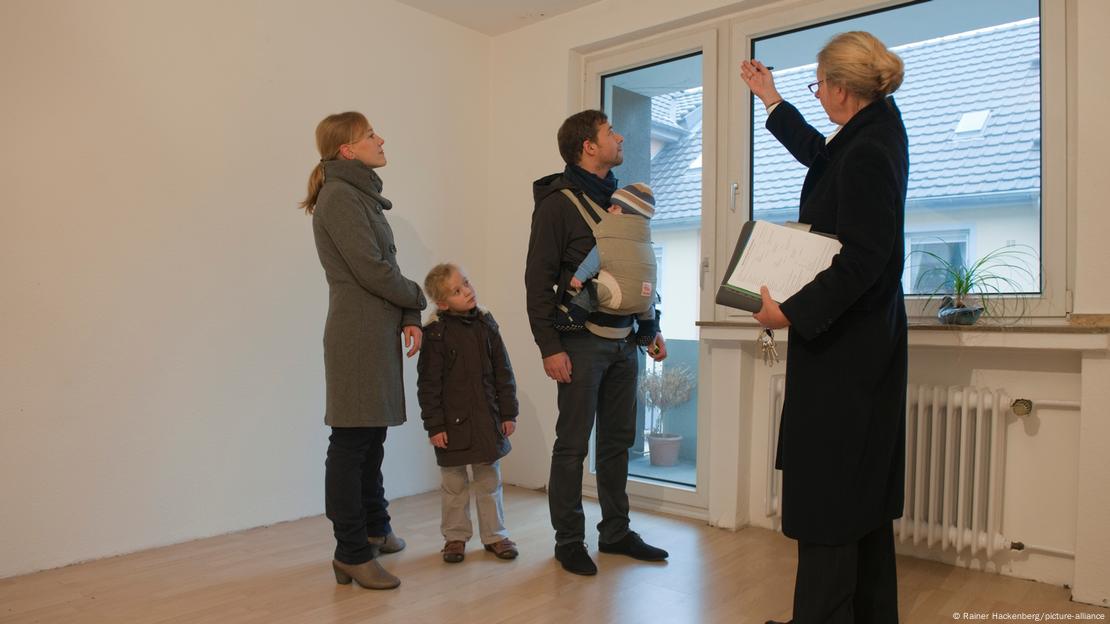 realtor showing around a young family of four