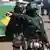 Policiais uniformizados com capacete em frente à bandeira do Brasil