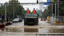 A paramilitary police vehicle wades through floodwaters after remnants of Typhoon Doksuri brought rains and floods in Beijing, China August 2, 2023. REUTERS/Tingshu Wang