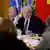 O presidente Luiz Inácio Lula da Silva (PT) durante café da manhã com jornalistas estrangeiros nesta quarta-feira (02/08). Ele está sentado a uma mesa, cercado por ministros de seu governo, enquanto fala e gesticula em direção a jornalistas que aparecem de costas, em primeiro plano e desfocados.