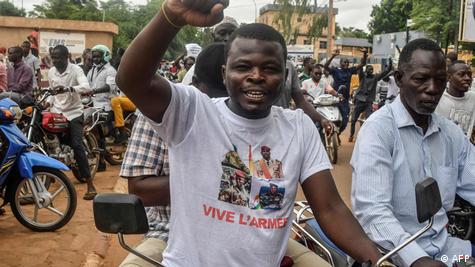Niamey'de 3 Ağustos Bağımsızlık Günü'nde üzerinde Nijer, Mali, Gine ve Burkina Faso'daki cunta liderlerinin fotoğrafları olan bir tişört giyen gösterici, darbecilere desteğini ortaya koyuyor.