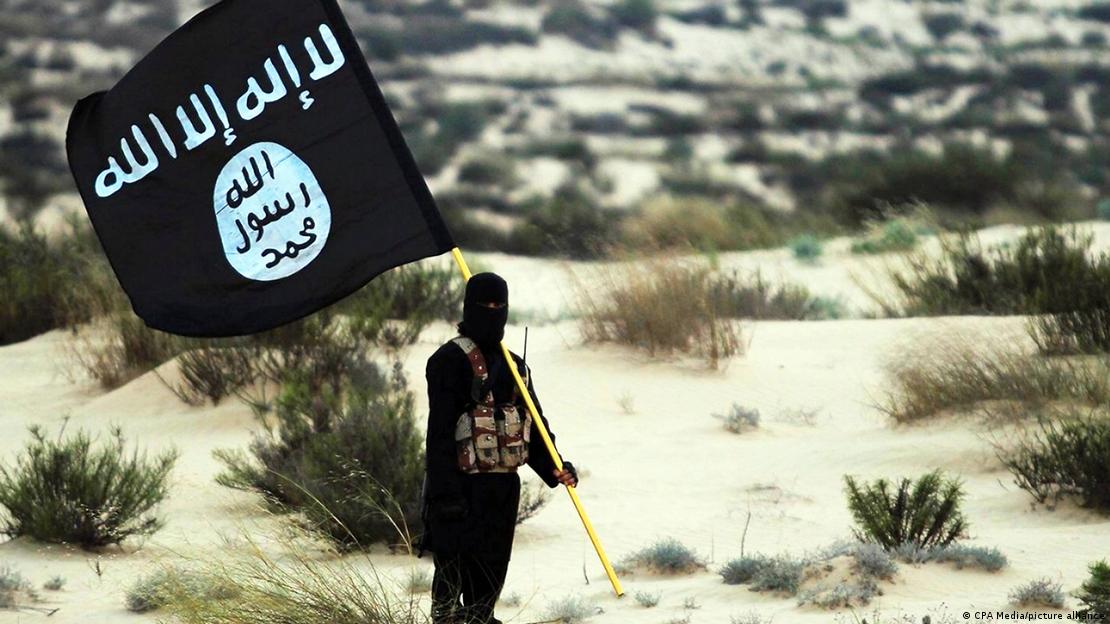 Një burrë duke mbajtur në dorv flamurin e ISIS