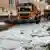 Veículo removedor de neve limpa gelo que cobre as ruas de cidade alemã